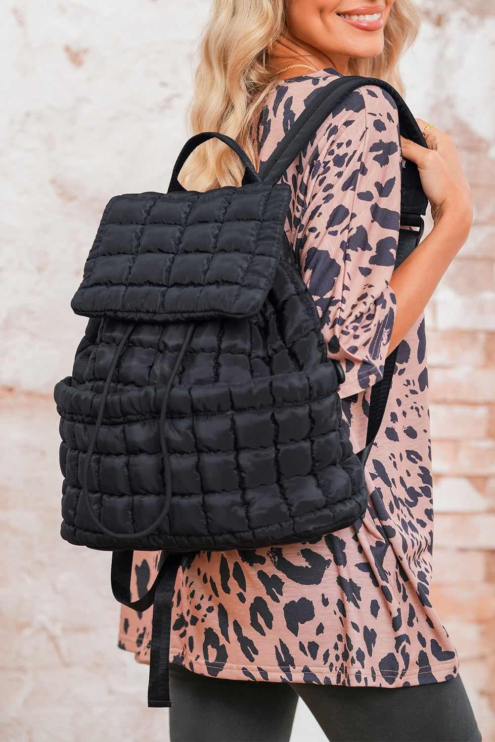 Black solid flapped quilted puffer backpack with spacious interior and modern design