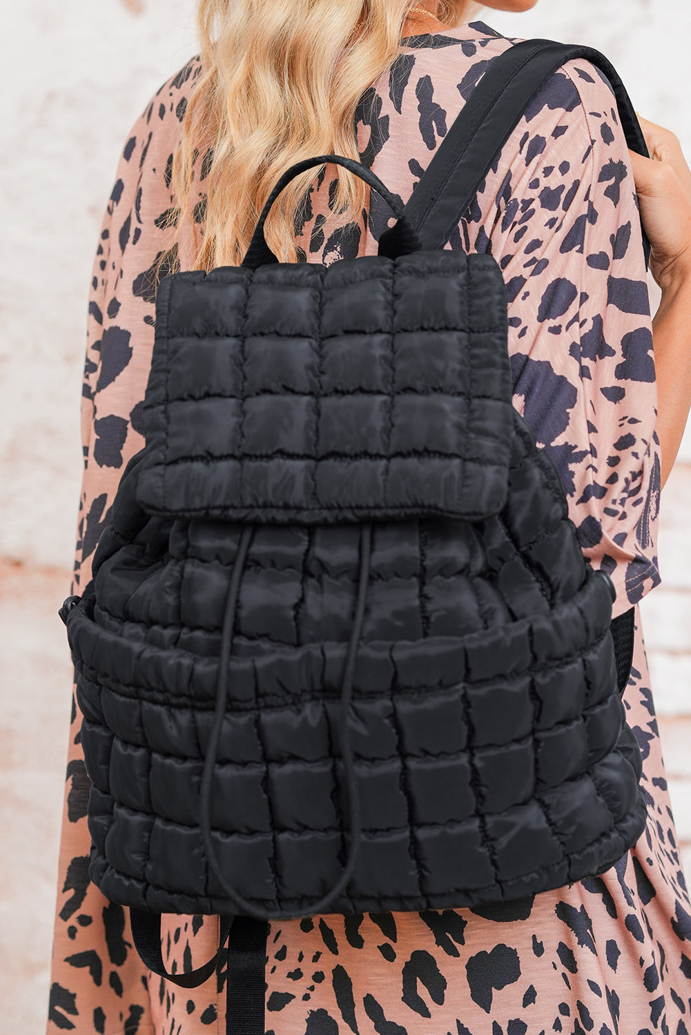 Black solid flapped quilted puffer backpack with spacious interior and modern stylish design