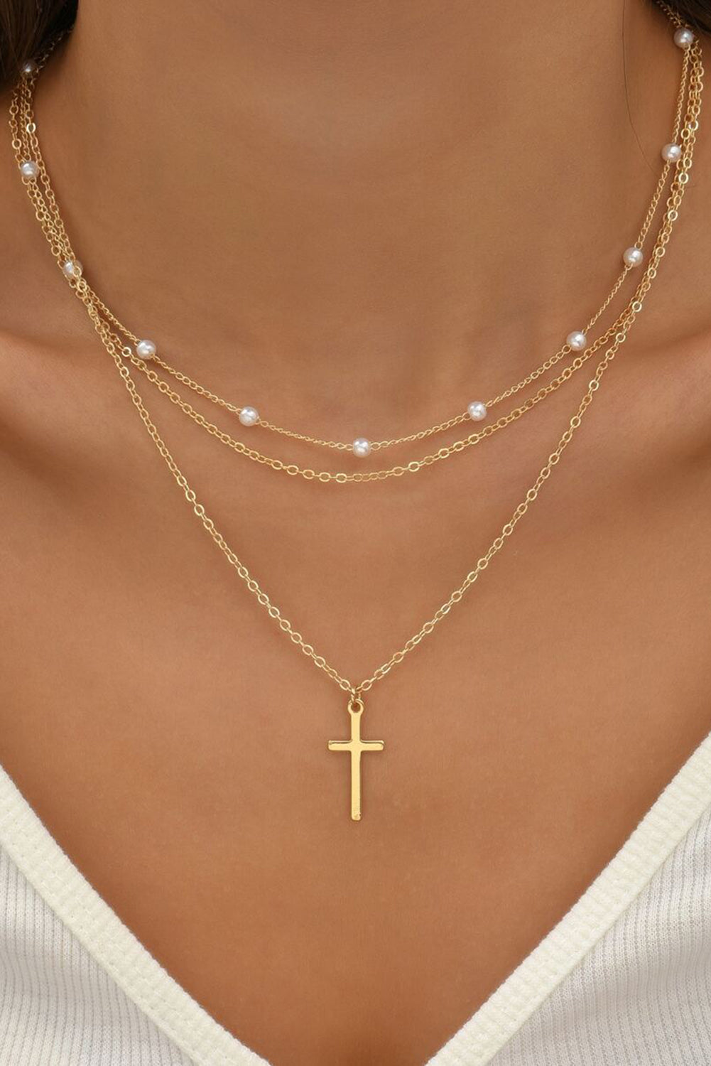 Gold plated cross pendant with pearl decor on triple layer chain necklace