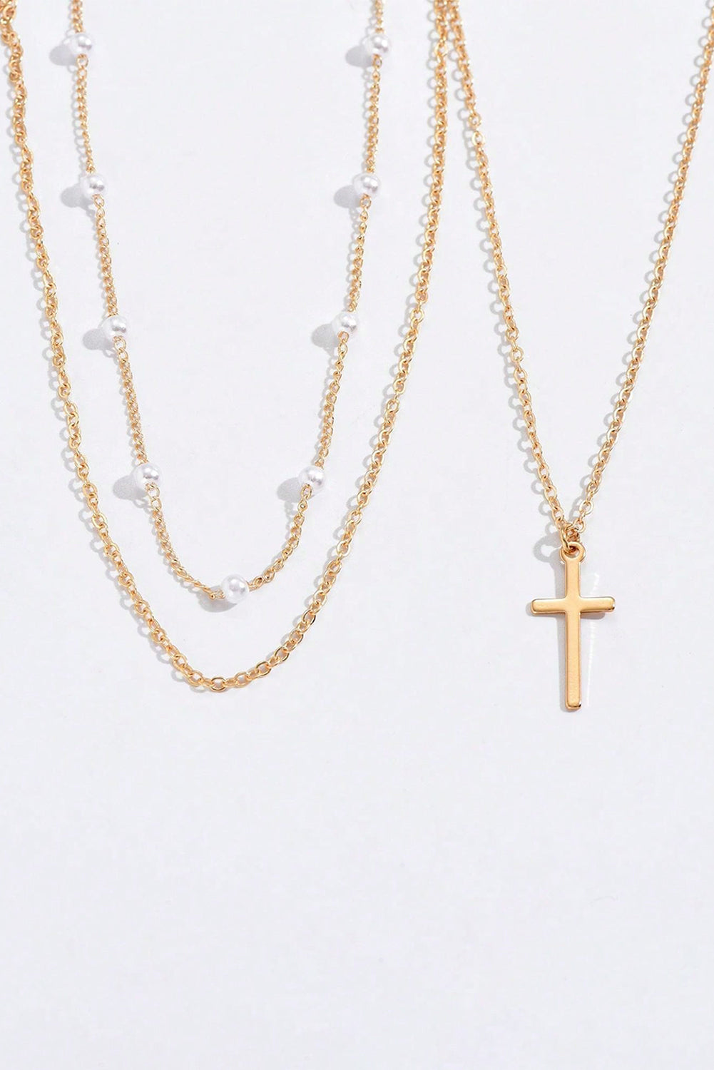 Gold plated cross pendant with pearl decoration on triple layer chain necklace