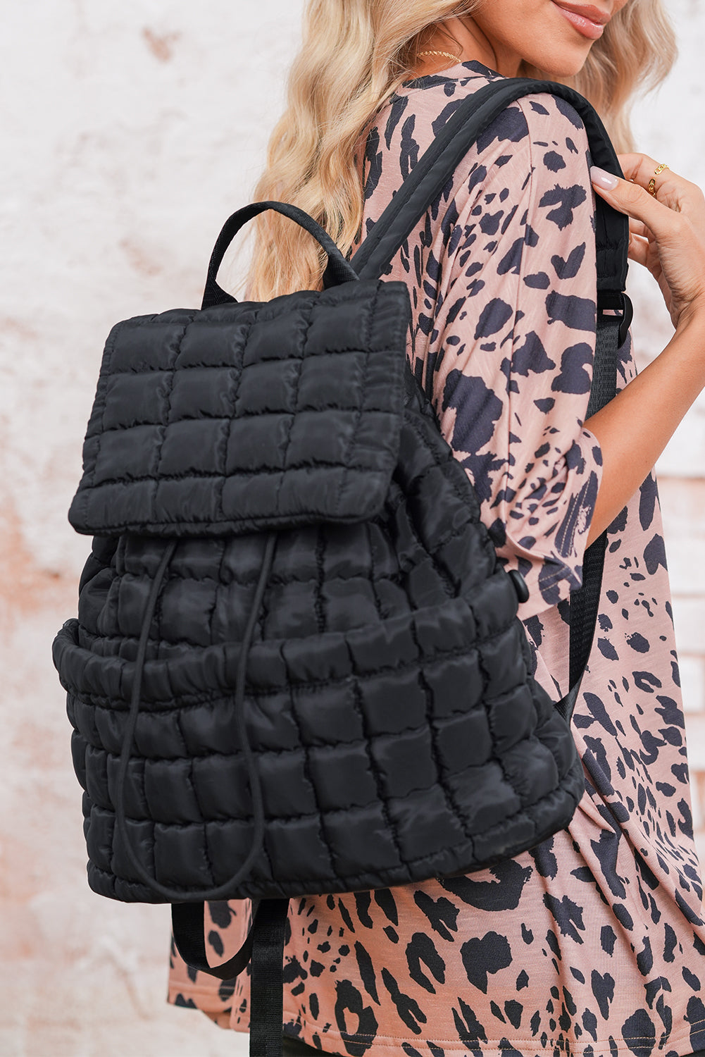 Black solid flapped quilted puffer backpack with spacious interior and modern design