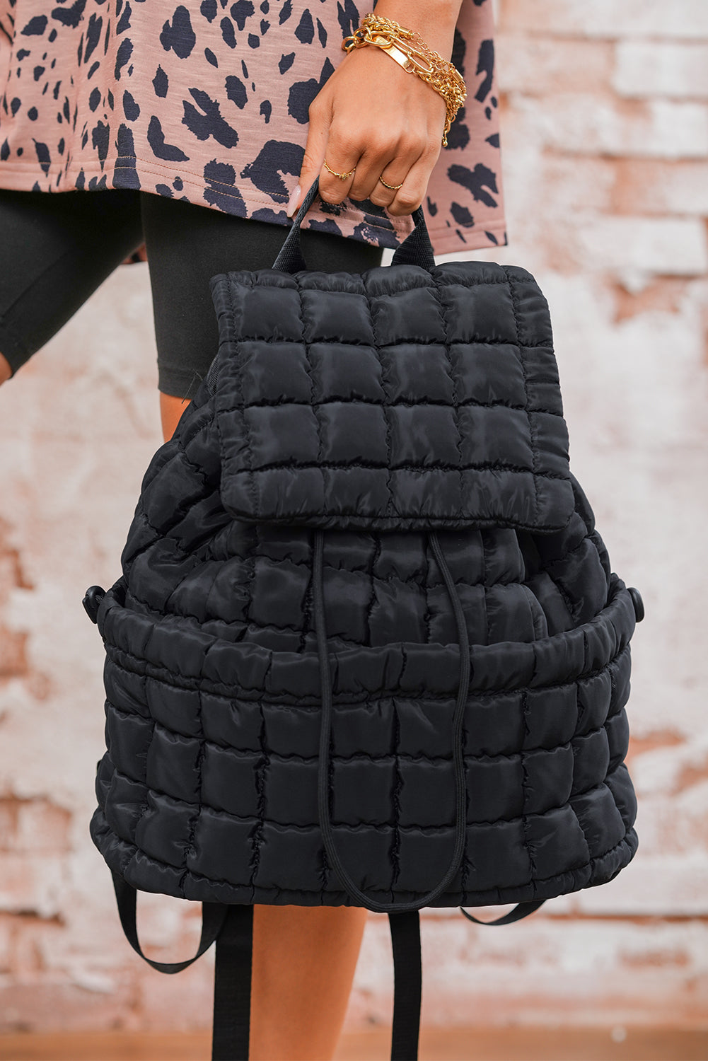 Black solid flapped quilted puffer backpack with spacious interior and modern design