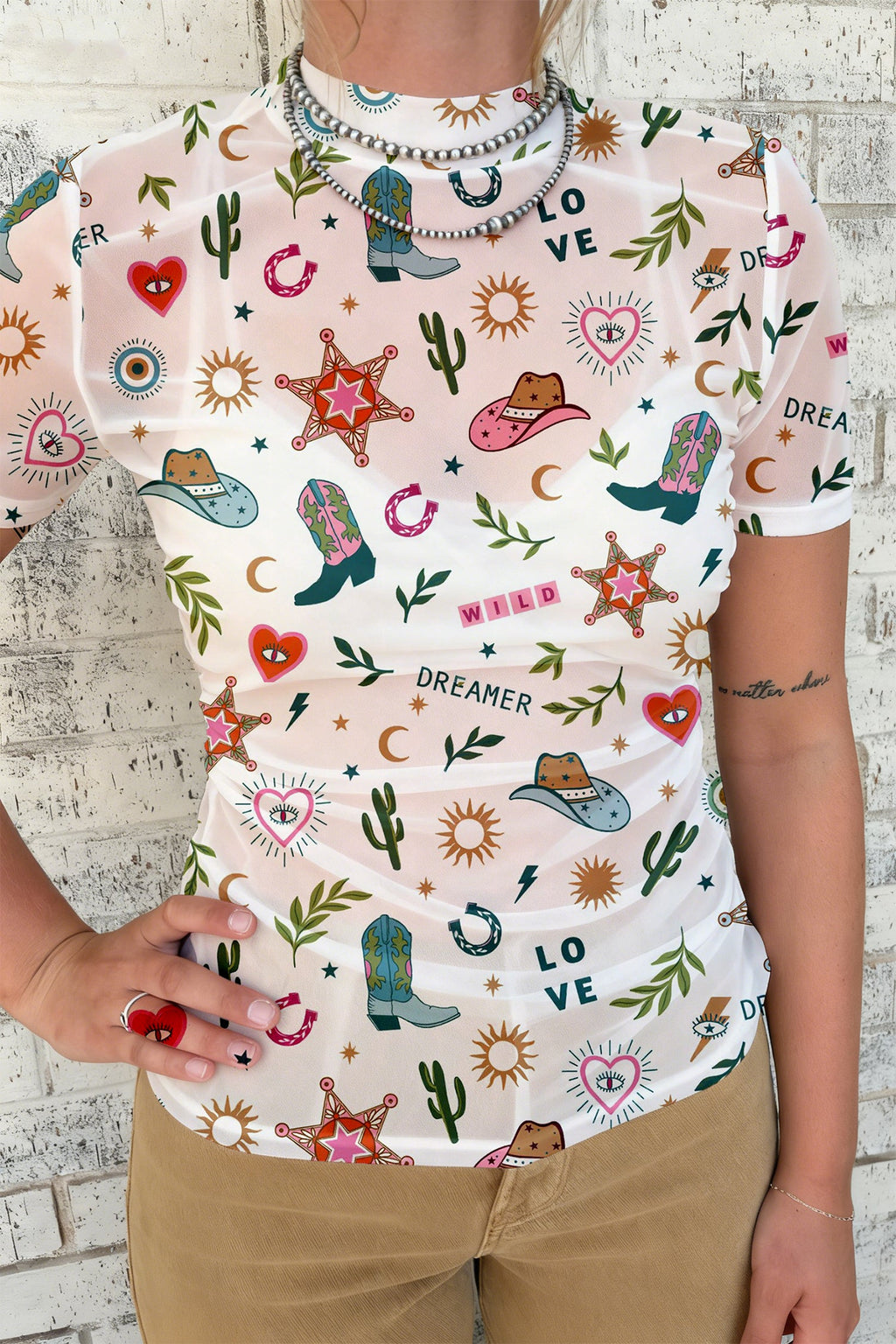 White sheer mesh top with Western print cowboy boots, stars, and cactus designs
