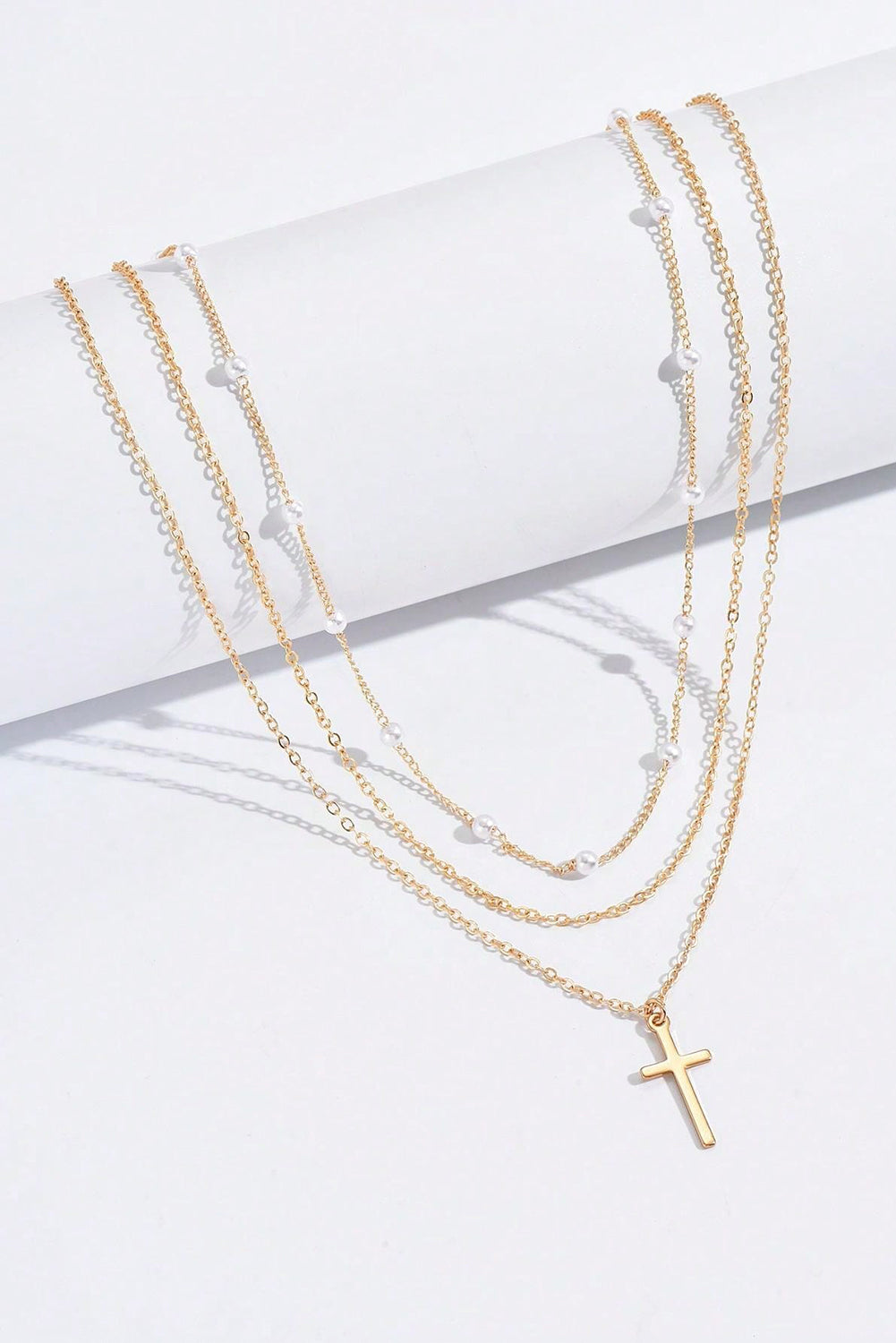 Gold plated cross pendant with pearl decor on triple layer chain necklace