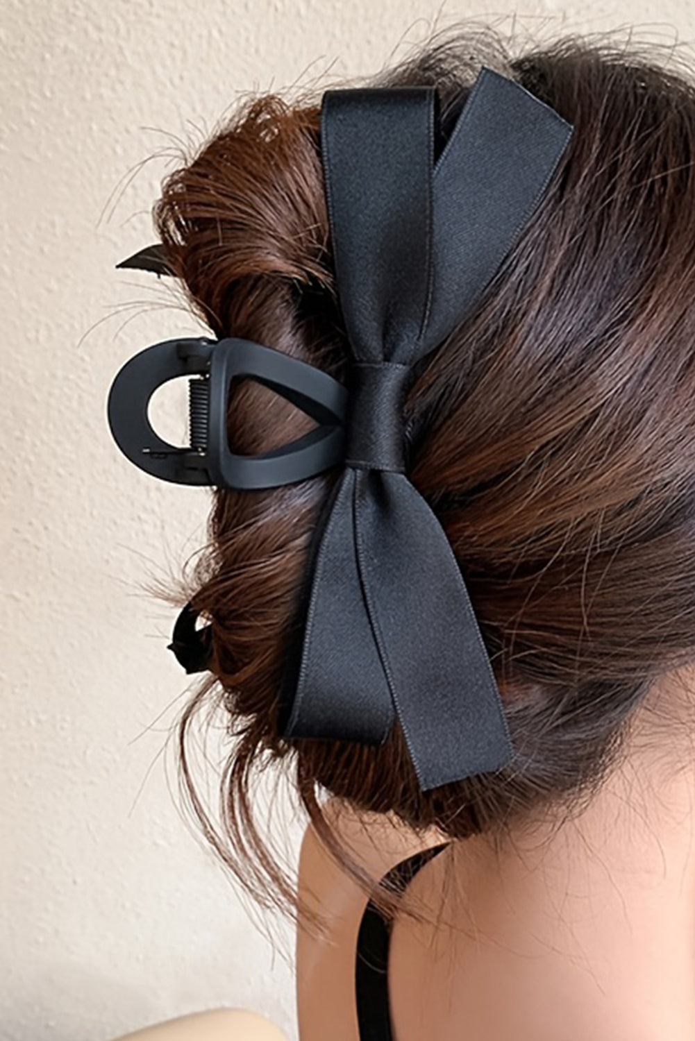 Large black bow decor hair claw clip securing thick hair