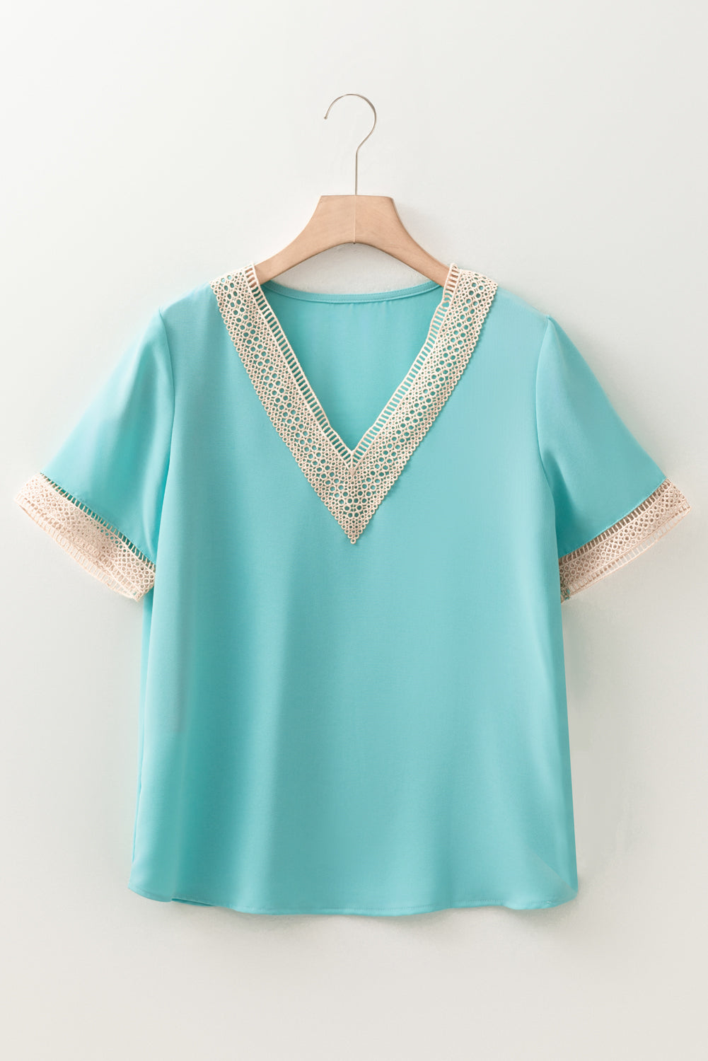 Green V-neck blouse with short sleeves and delicate lace trim detail