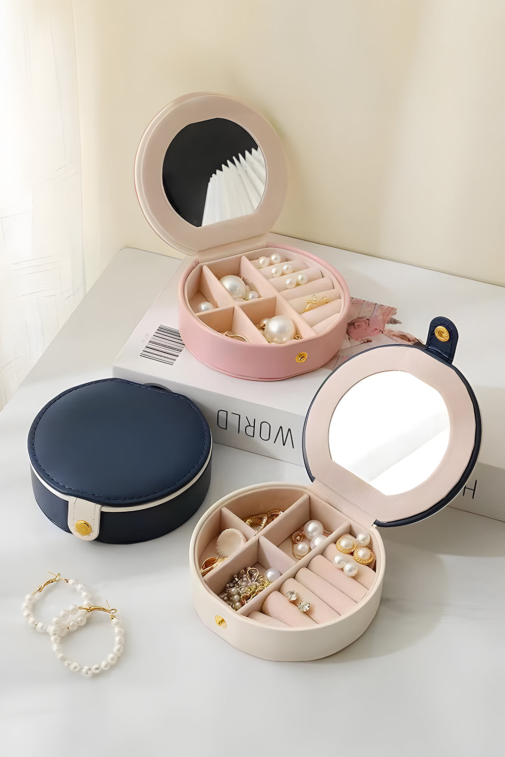Light pink jewelry organizer case with built-in mirror and snap button closure, compact and stylish design
