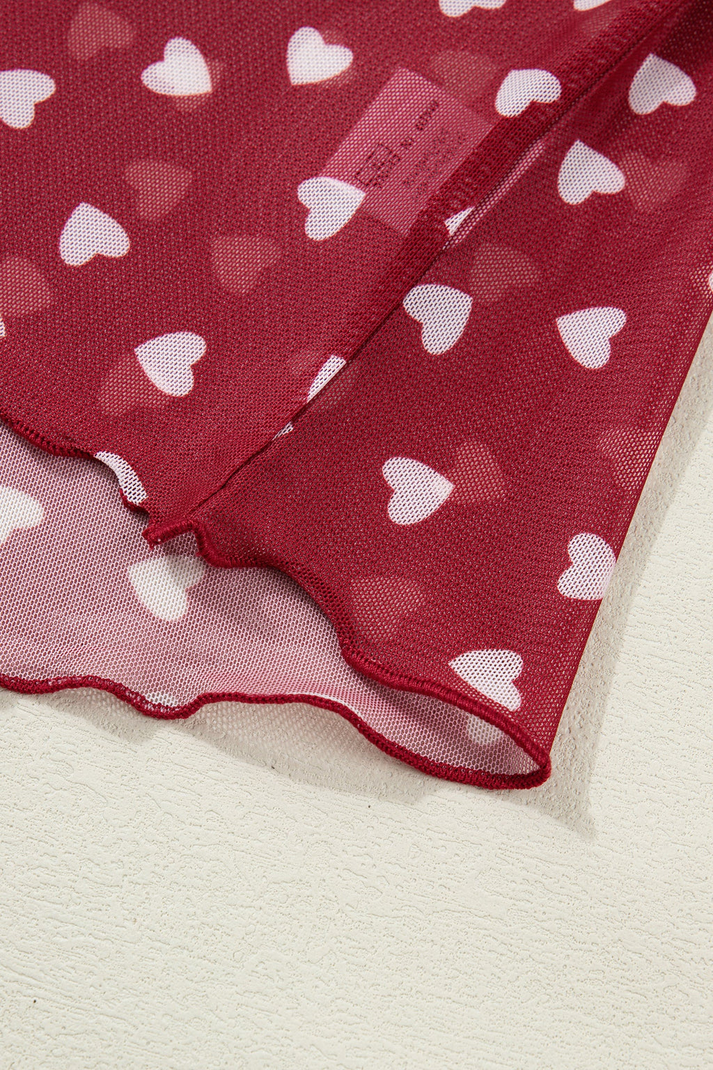 Pink mesh crop top with allover heart print and lettuce trim neckline