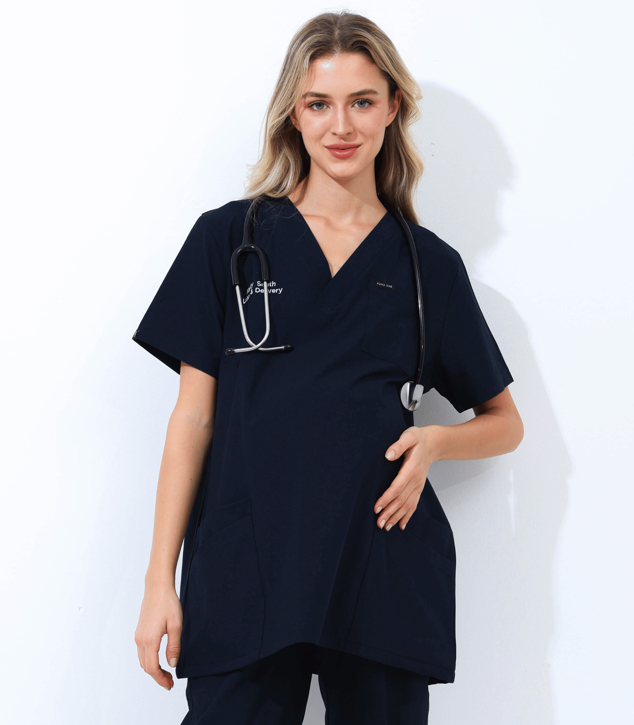 Pregnant medical professional wearing stylish and comfortable maternity scrubs from the Maternity Scrubs Collection