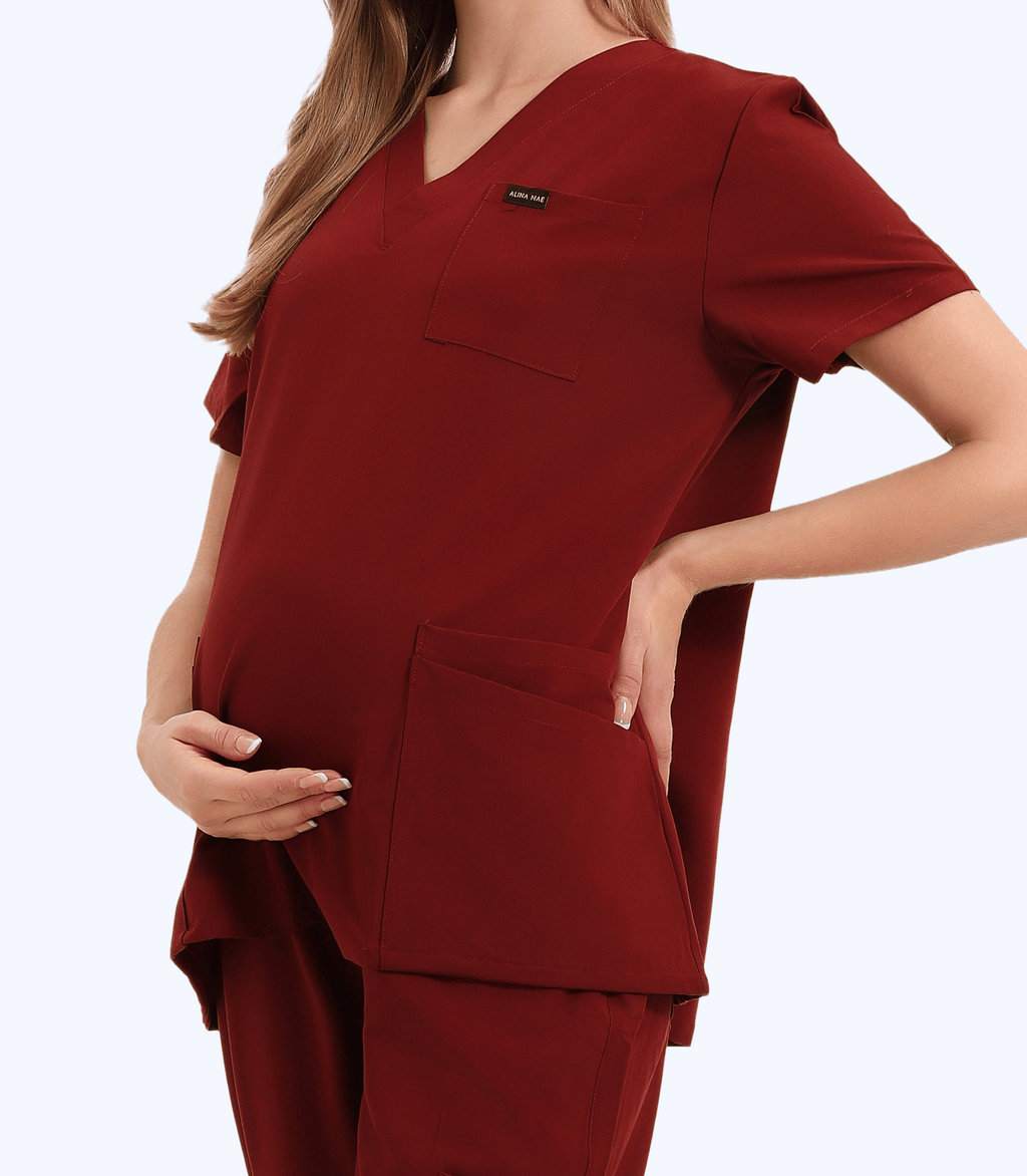 Pregnant medical professional wearing stylish and comfortable Mae maternity scrub top from Maternity Scrubs Collection