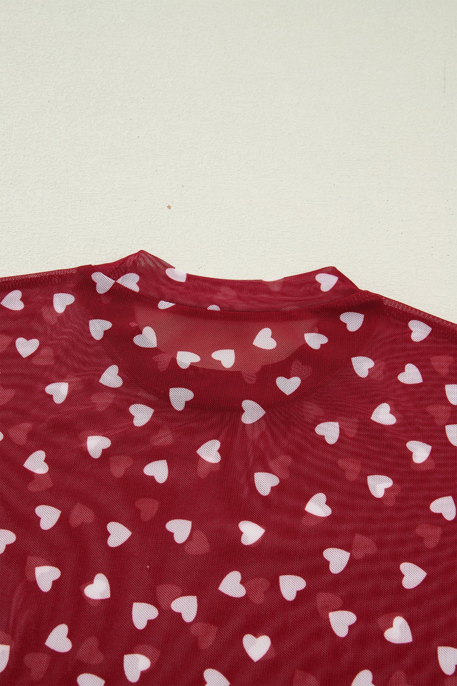 Pink sheer mesh crop top with allover heart print and lettuce trim