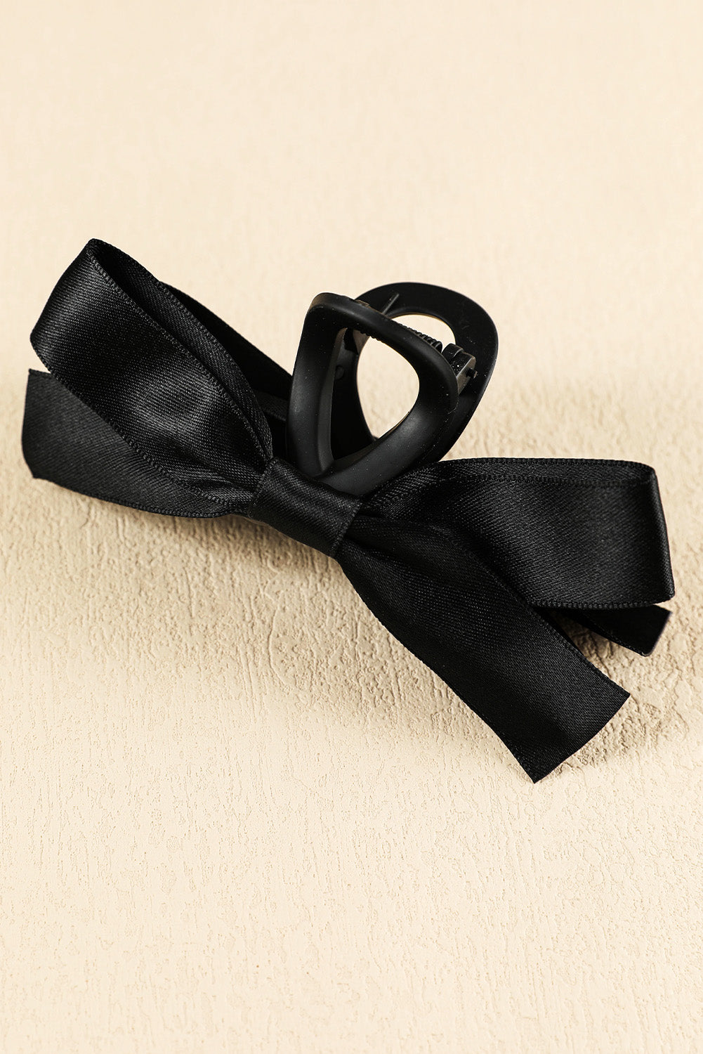 Large black hair claw clip with elegant bow decor for securing all hair types