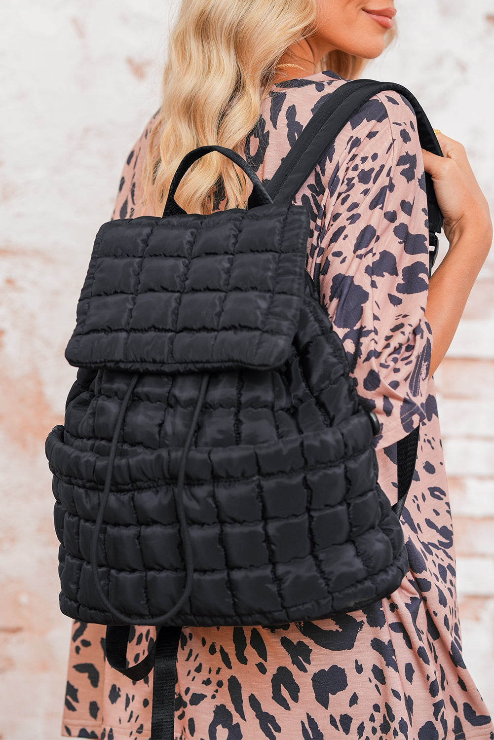 Black solid flapped quilted puffer backpack with spacious interior and modern design