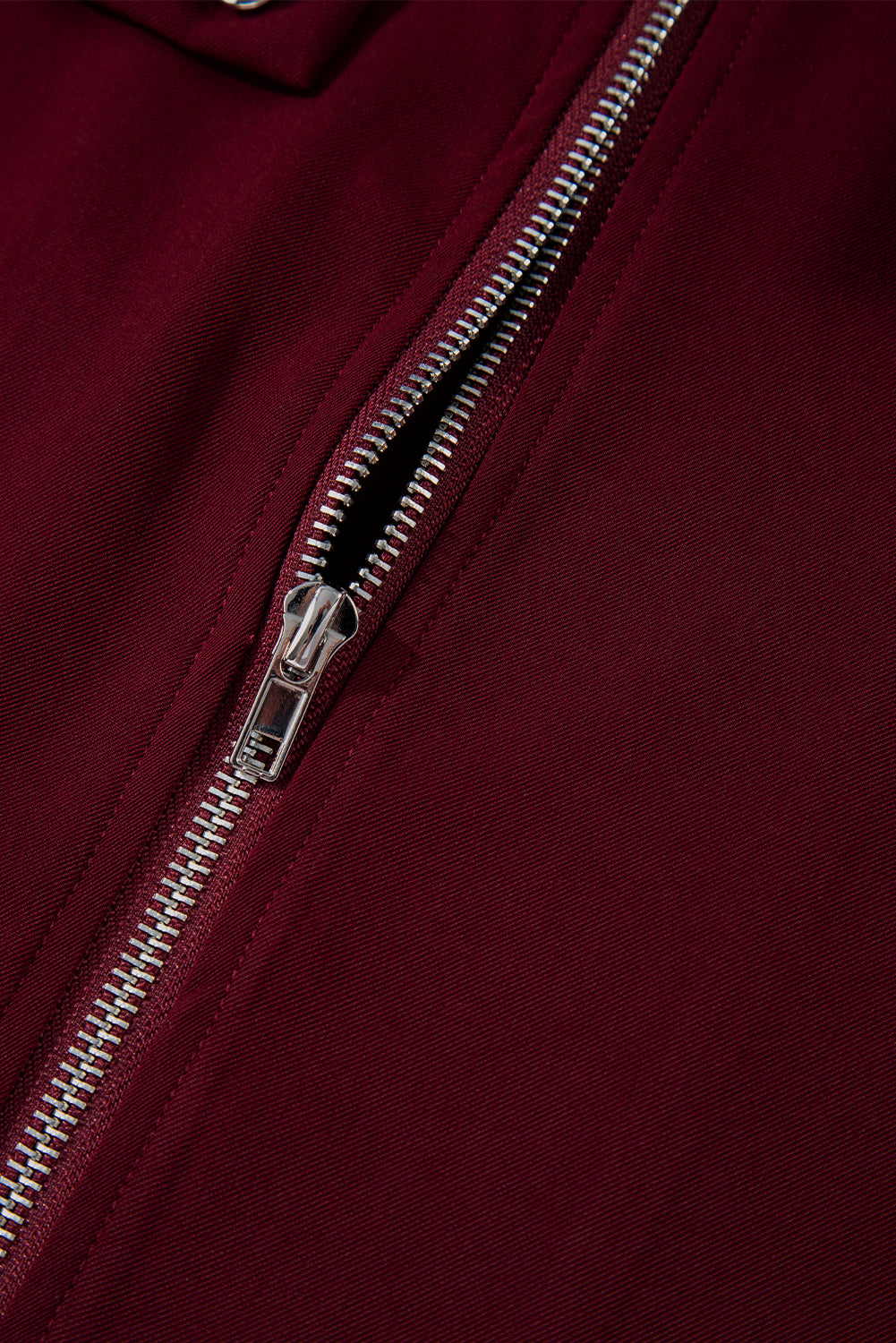 Black jacket with collar and tab sleeve detail featuring a zip-up closure