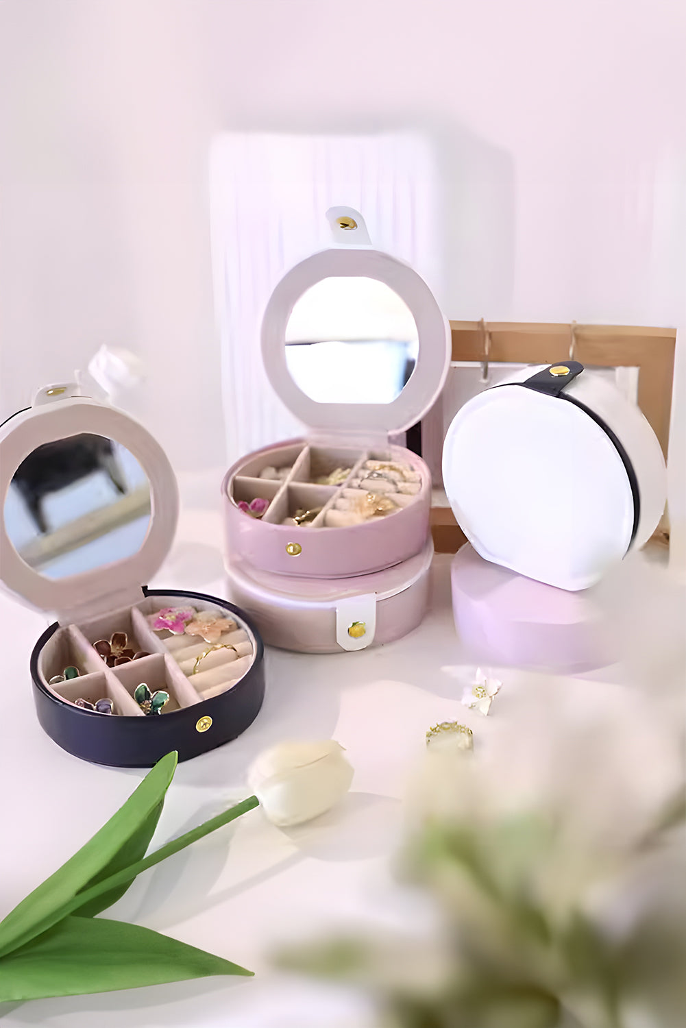 Light pink jewelry organizer cases with mirror and snap button closure in compact round shape