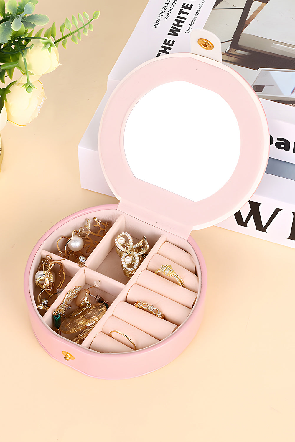 Light pink round jewelry organizer case with snap button and built-in mirror